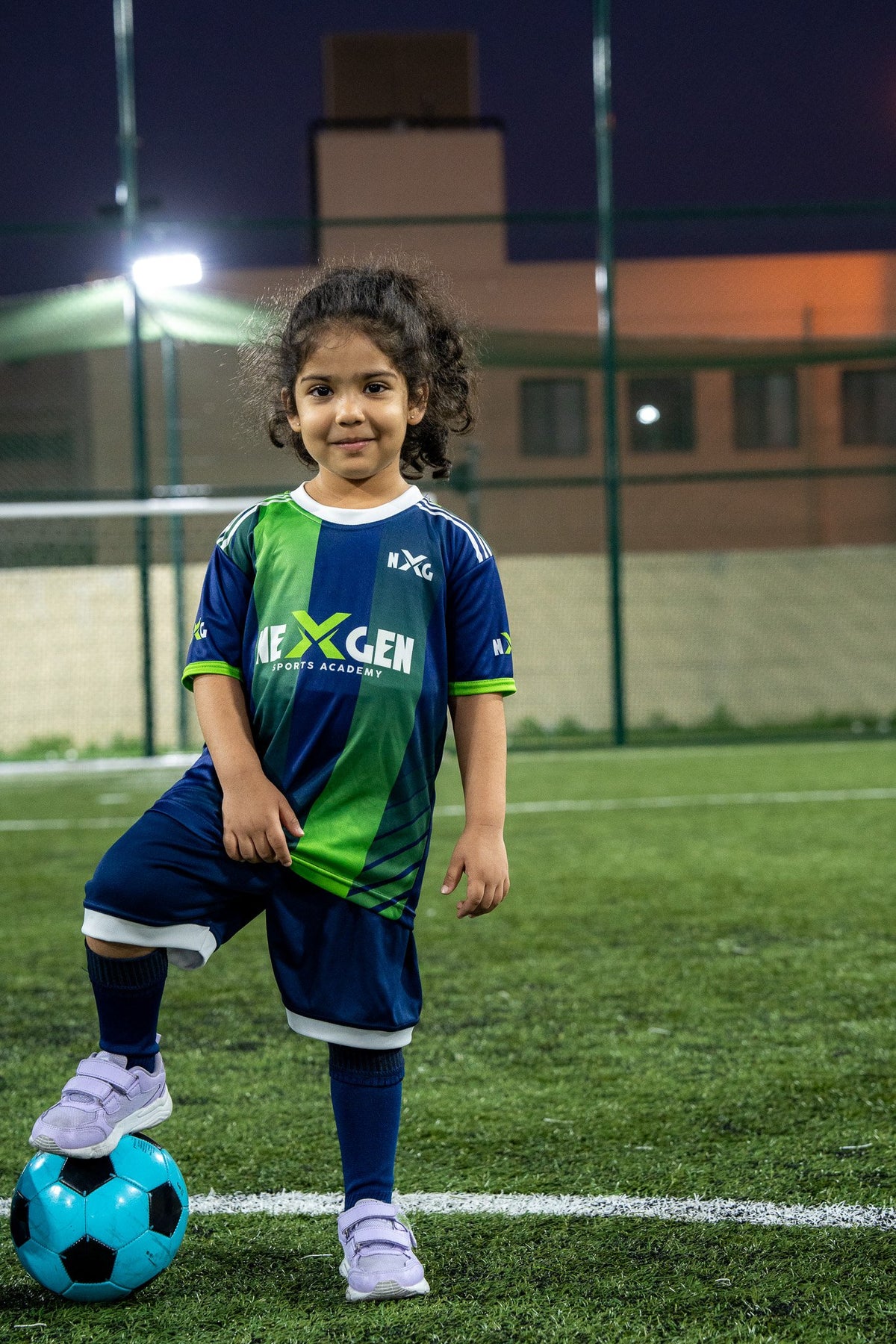 Young NEXGEN player smiling with her football