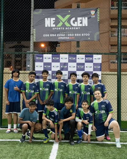 NEXGEN squad in front of the academy banner
